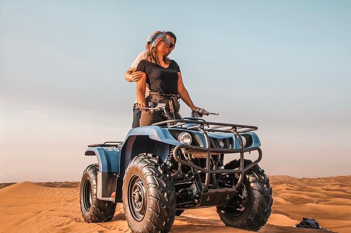 Experience the stunning desert landscape of Dubai on a quad bike capturing unforgettable moments at the peak of rolling dunes. Perfect for family adventures or romantic escapades.